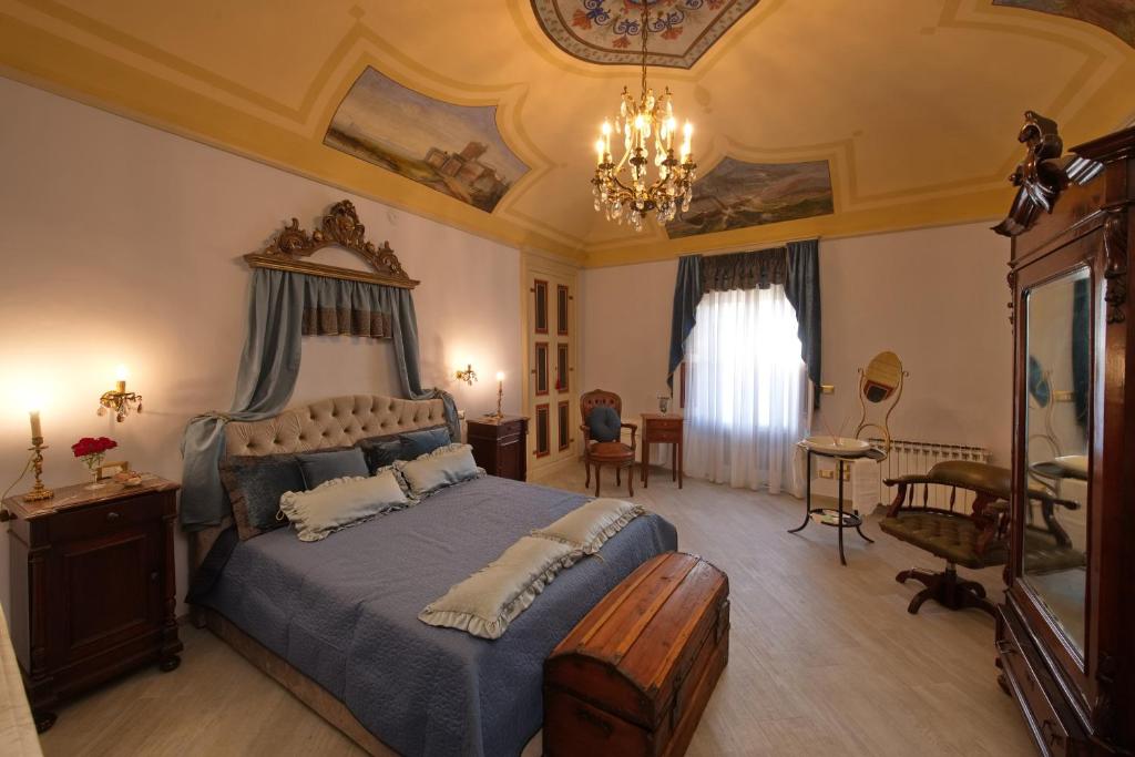 Un dormitorio con una cama grande y una lámpara de araña. en Villa Albaluce, en Caluso
