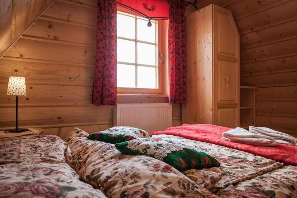 a bedroom with two beds in a log cabin at Przytulne Domki u Kantora nr 2 in Poronin