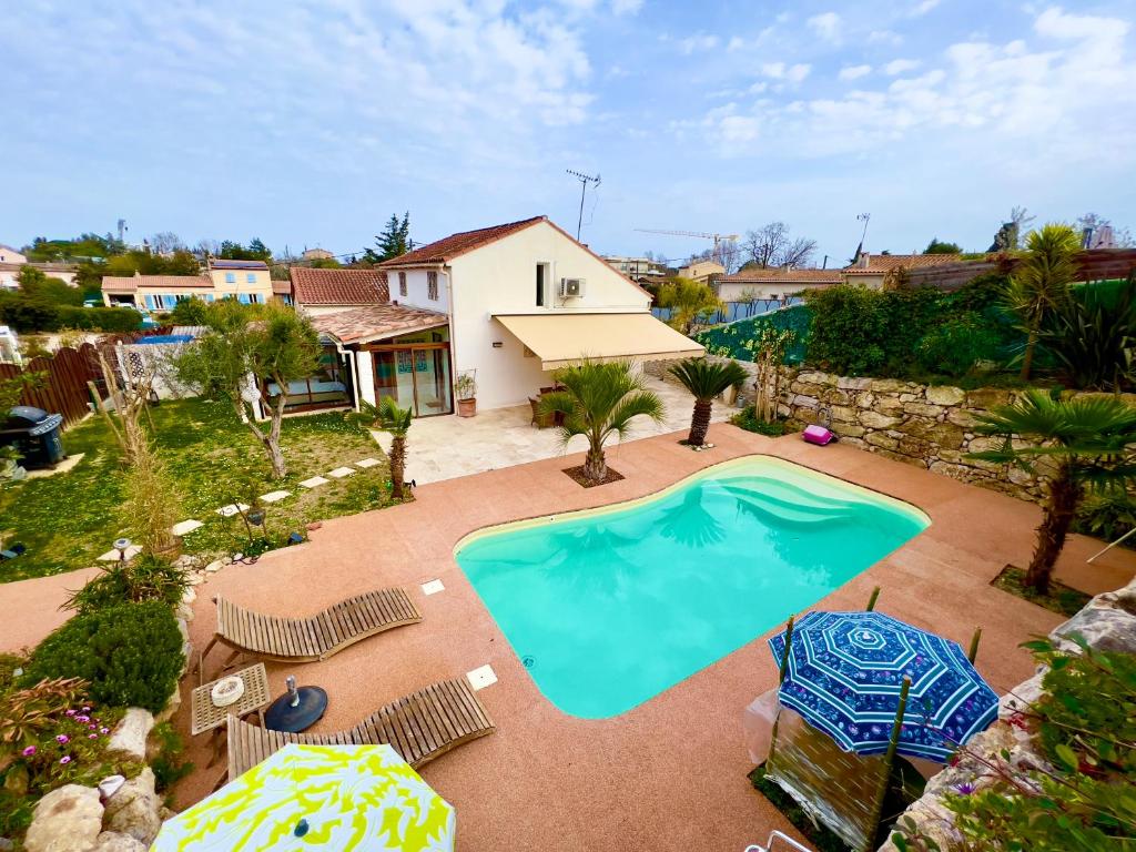 - une vue sur la piscine bordée de chaises et de parasols dans l'établissement Villa Natval - 600 m2, à Antibes
