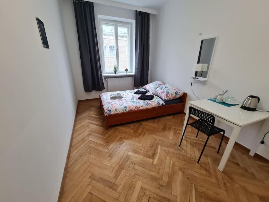 a bedroom with a bed and a desk and a table at Fantastic - O13 Room F in Warsaw