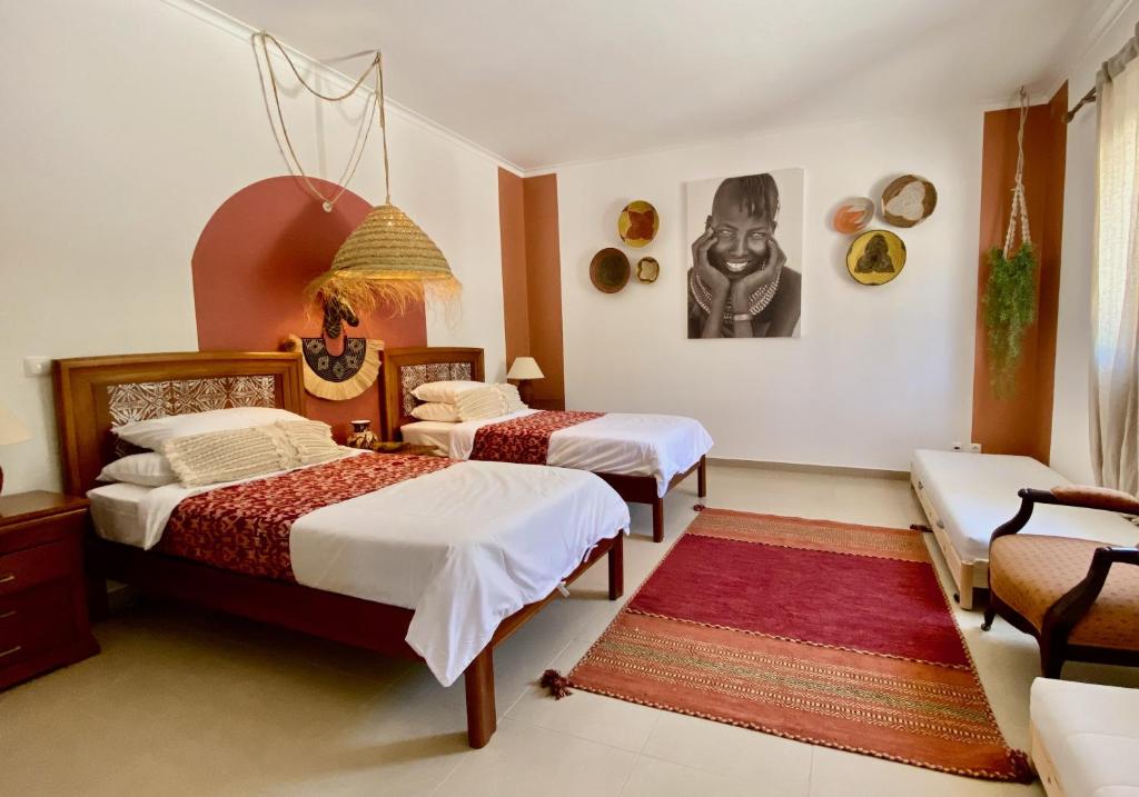 a bedroom with two beds and a rug at Casa do Monte in Loulé
