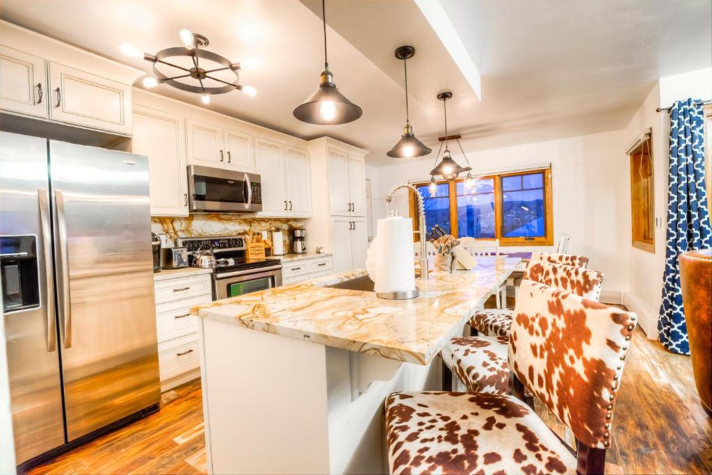 een keuken met witte kasten en een marmeren aanrecht bij Phoenix 225 in Steamboat Springs