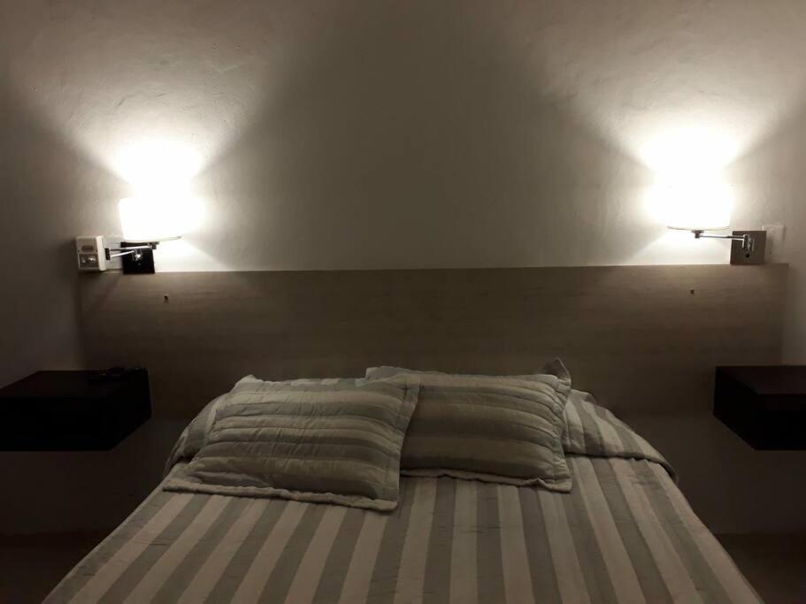 1 dormitorio con 1 cama con 2 luces en la pared en Alquiler en San Rafael en San Rafael