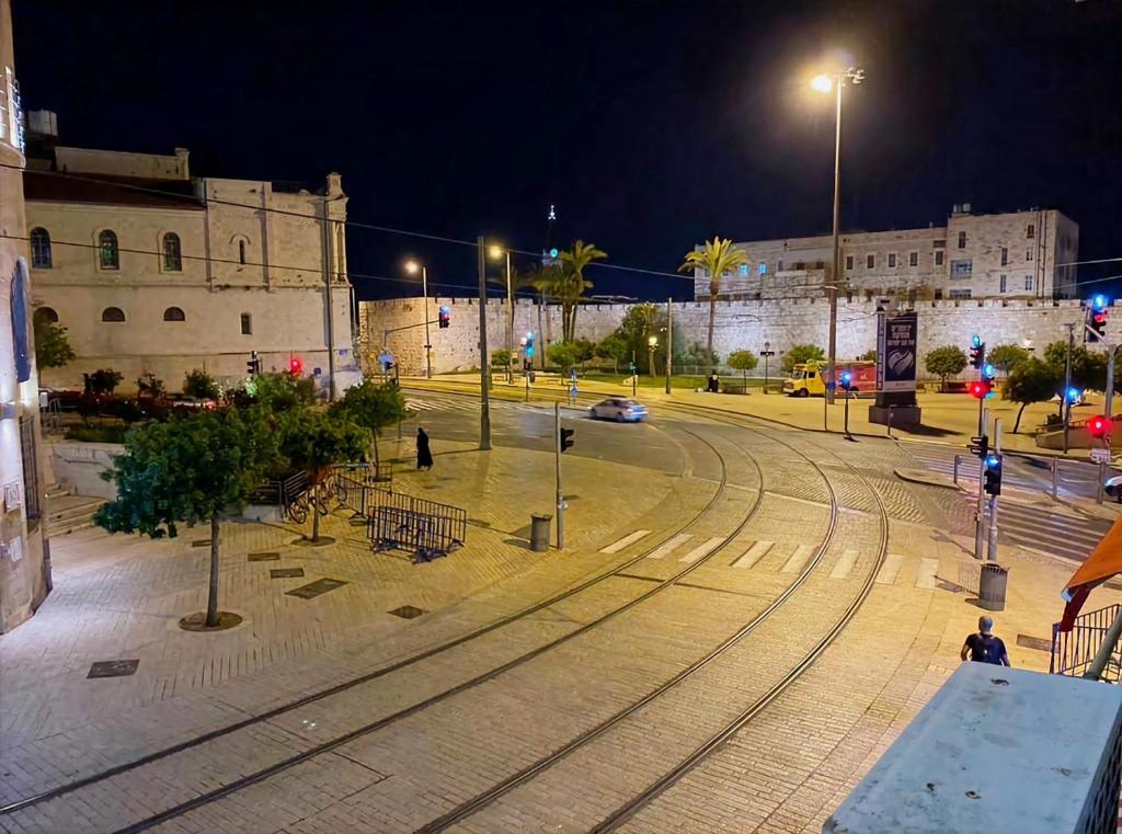 una calle de la ciudad por la noche con luces de la calle y vías de tren en Jaffa 17 - Lihi brand new studio en Jerusalén
