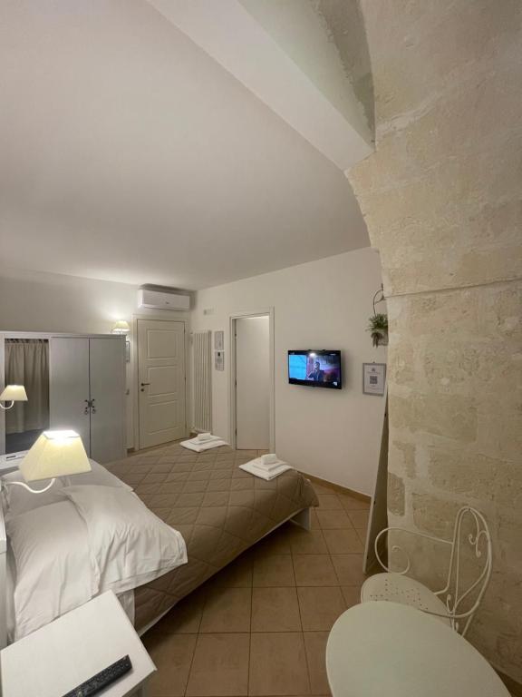een slaapkamer met een bed en een tv aan de muur bij Antica Mateola in Matera