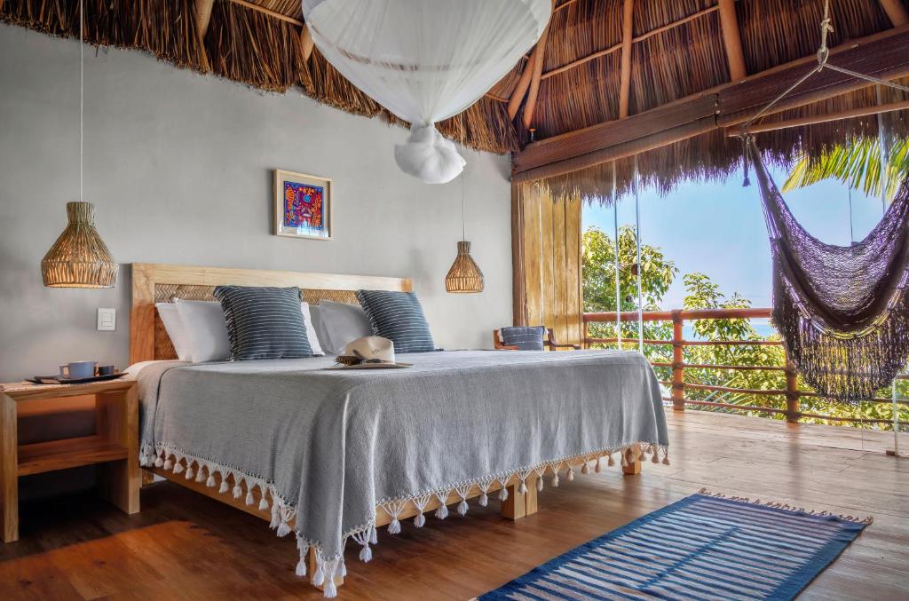 a bedroom with a bed and a large window at Xinalani Retreat Mexico in Qumiste