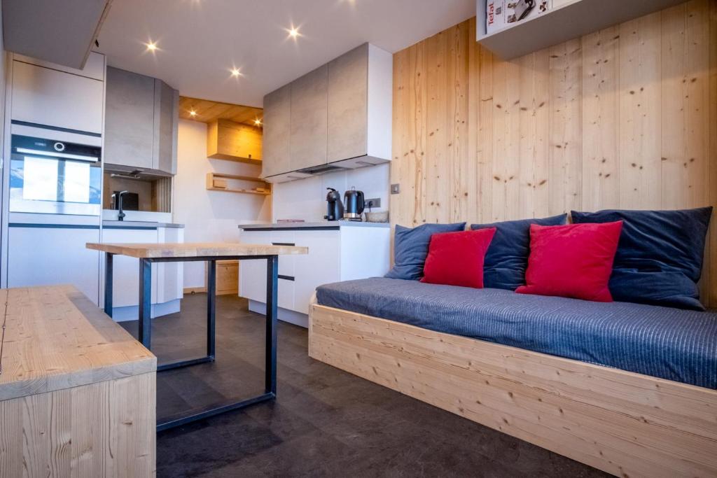 uma sala de estar com um sofá azul e uma mesa em Comfortable studio with balcony - Huez - Welkeys em LʼHuez
