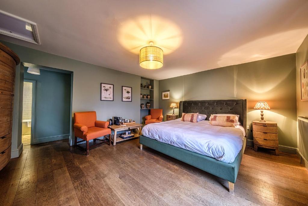 a bedroom with a bed and two orange chairs at The Globe Inn in Wells next the Sea