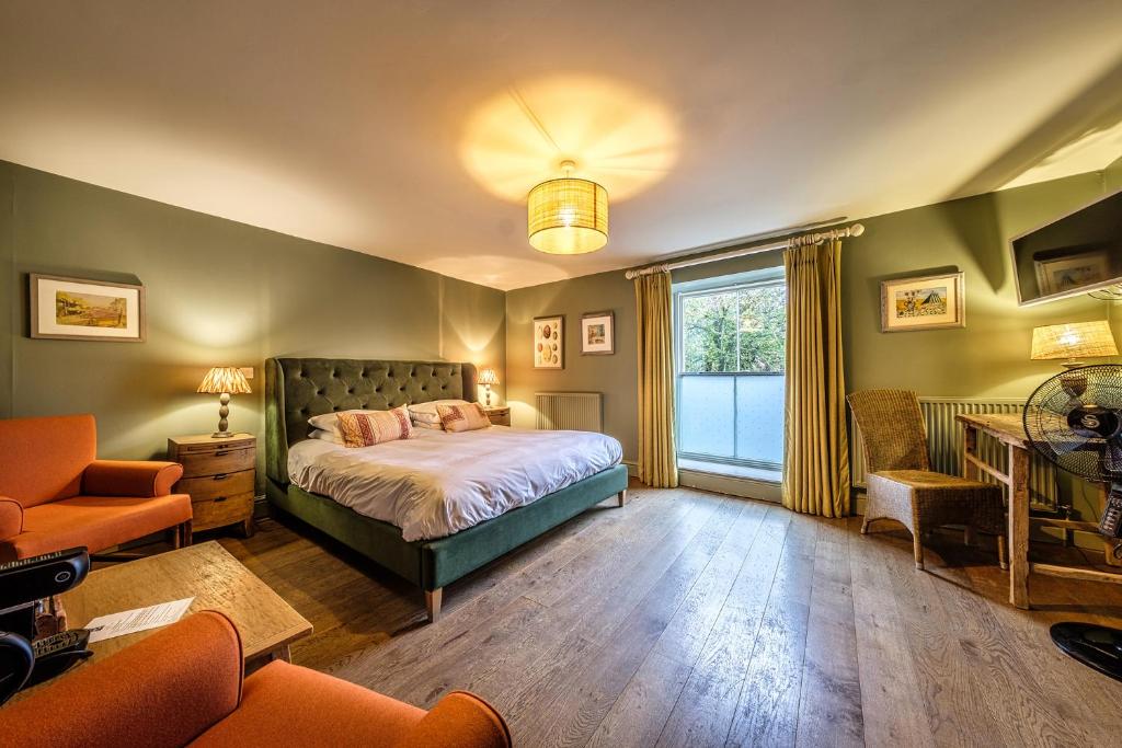 um quarto com uma cama, uma cadeira e uma janela em The Globe Inn em Wells-next-the-Sea