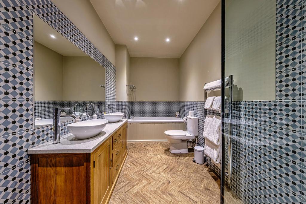 a bathroom with two sinks and a toilet and a tub at The Globe Inn in Wells next the Sea