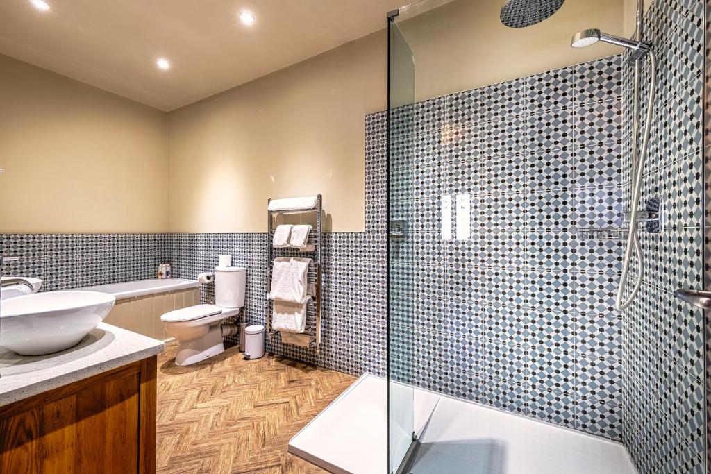 a bathroom with a toilet and a glass shower at The Globe Inn in Wells next the Sea