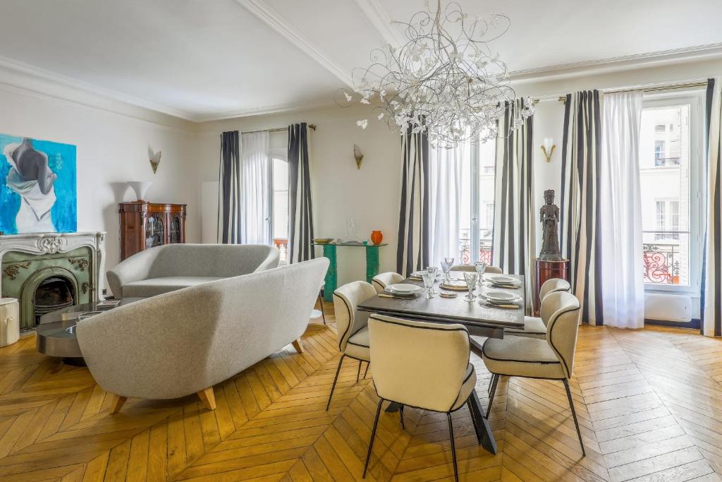 una sala de estar con una mesa y sillas en Appartement du Pilot - Welkeys, en Neuilly-sur-Seine