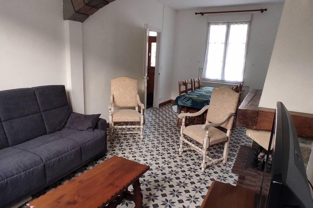 a living room with a couch and chairs and a table at maison de ville pour 6 personnes in Montdidier