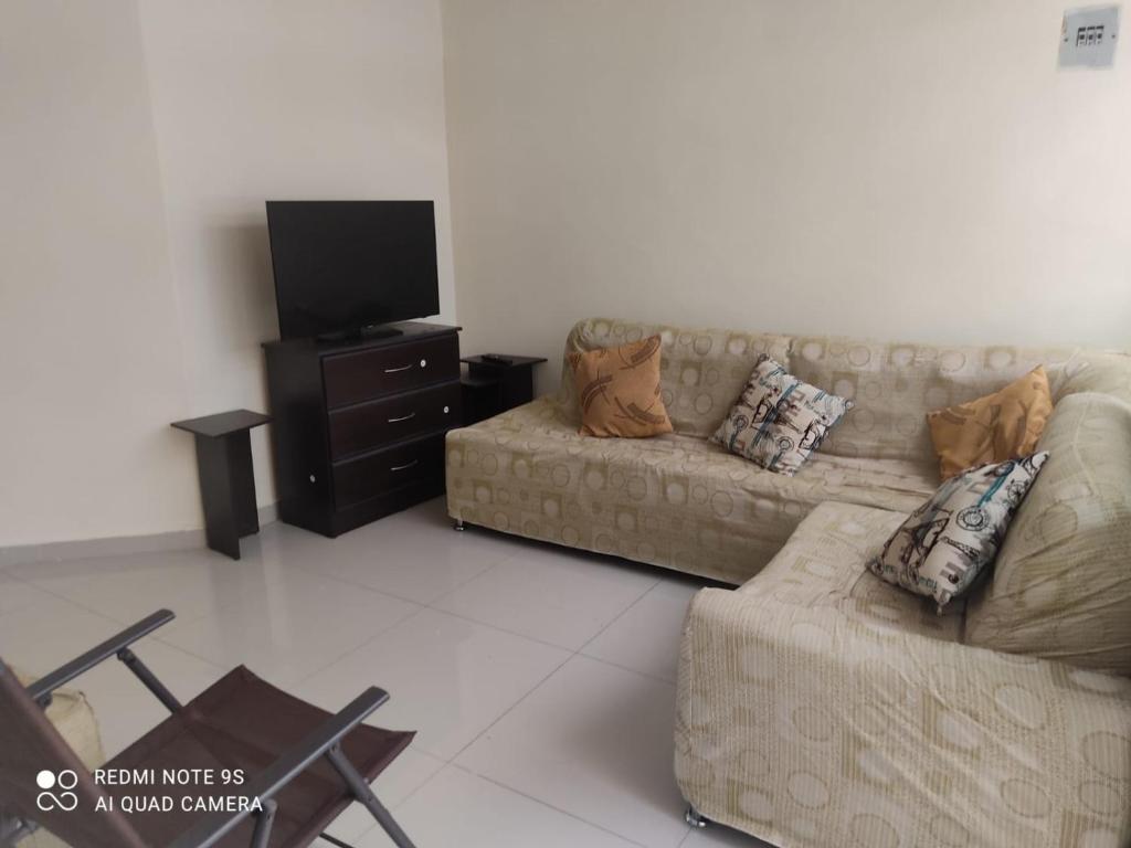 sala de estar con sofá y TV en HERMOSO APARTAMENTO CON TERRAZA, en Ibagué