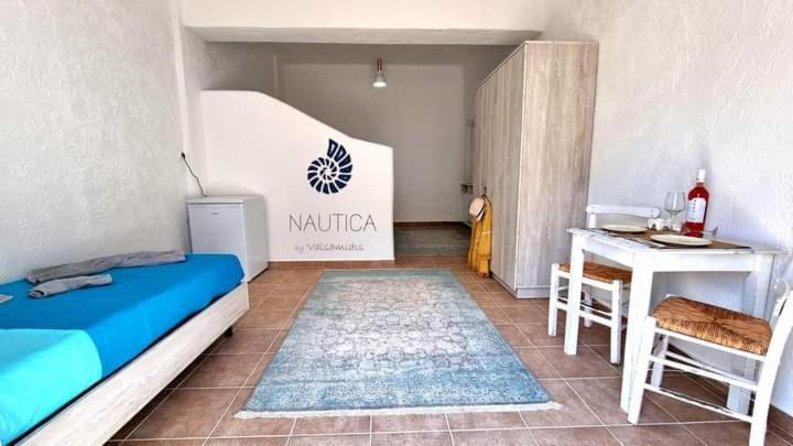 a bedroom with a bed and a desk and a table at Nautica by Valsamidis in Vlychádia