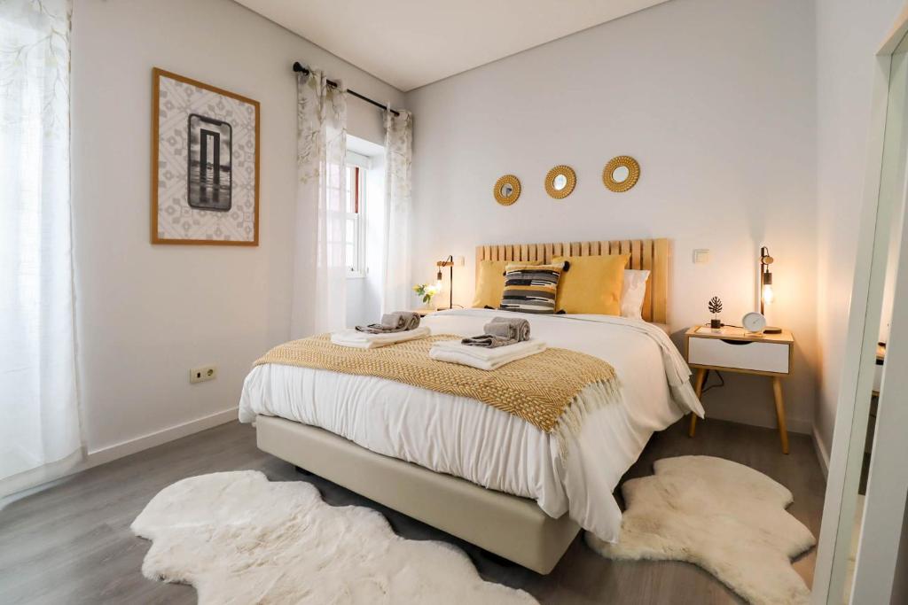 een slaapkamer met een groot bed met tapijten bij Viana Central - Historical City Centre Apartment in Viana do Castelo