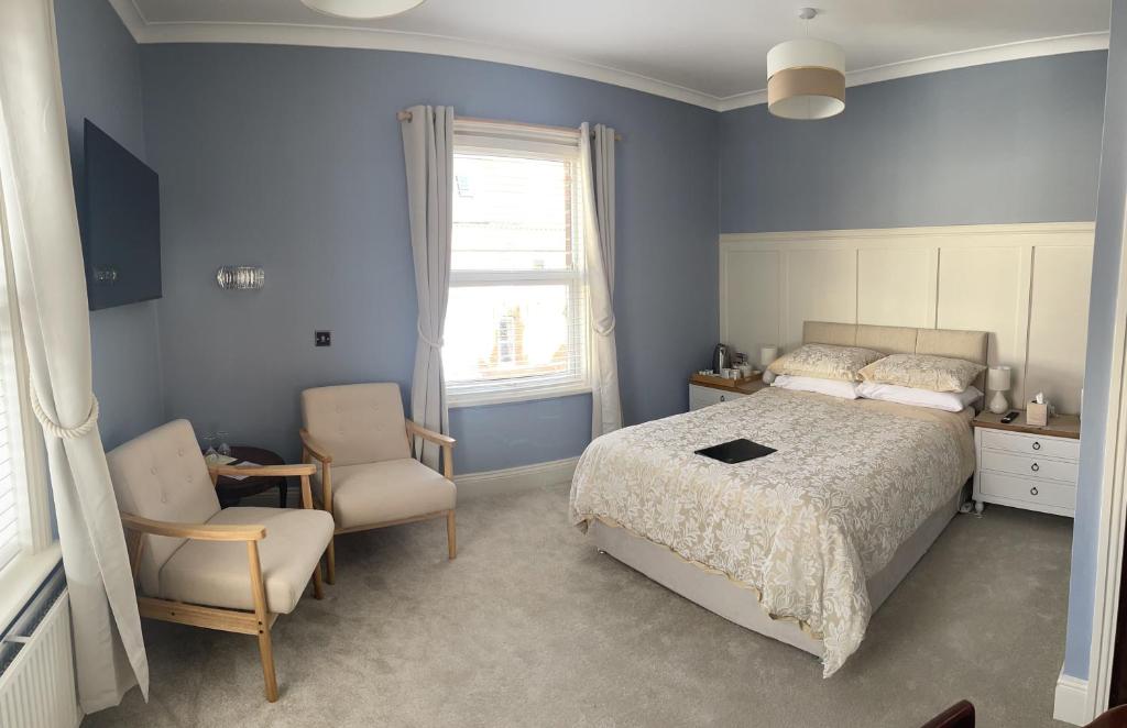 a bedroom with a bed and a chair and a window at Doriam Guest House in Bridlington