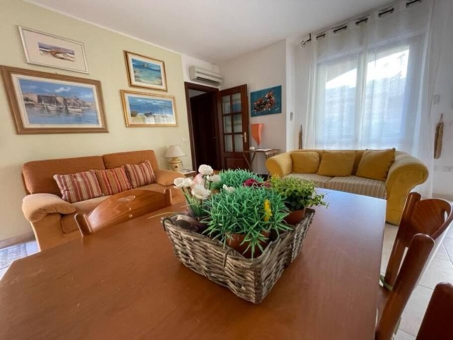 een woonkamer met een tafel met bloemen erop bij Civico 8bis Casa Vacanze in Alghero