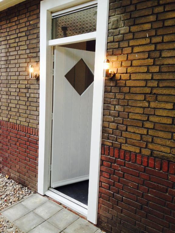 an open door into a brick house at Rustige, zelfstandige studio- uitsluitend 1 persoon in Dedemsvaart