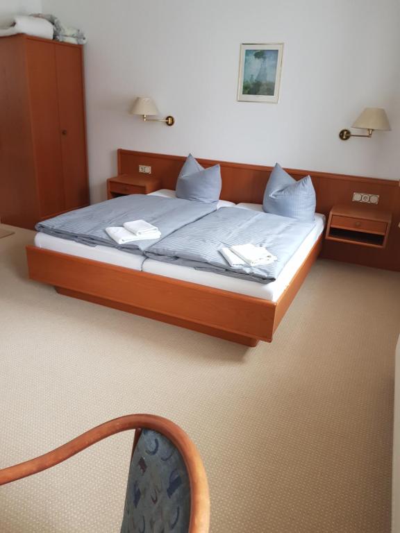 Hotel zur Altstadt في Calbe: غرفة نوم بسرير وملاءات زرقاء وكرسي
