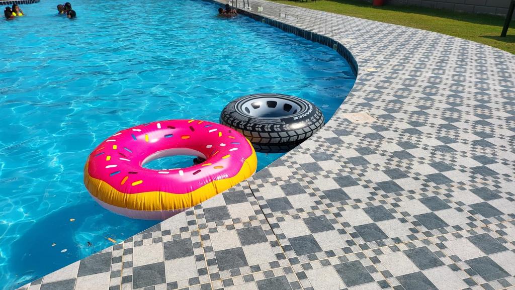 a donut and a tire in a swimming pool at Mona chalet "Families only" عائلات فقط in Al Khīrān