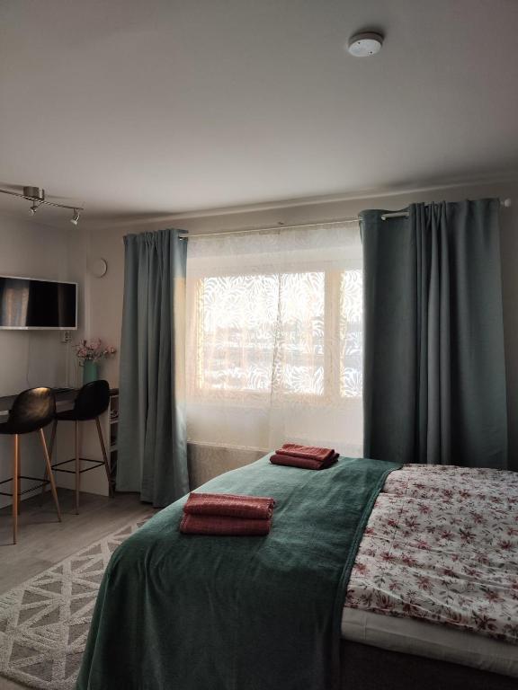 ein Schlafzimmer mit einem Bett mit zwei roten Kissen darauf in der Unterkunft 57 Kauppakatu in Varkaus