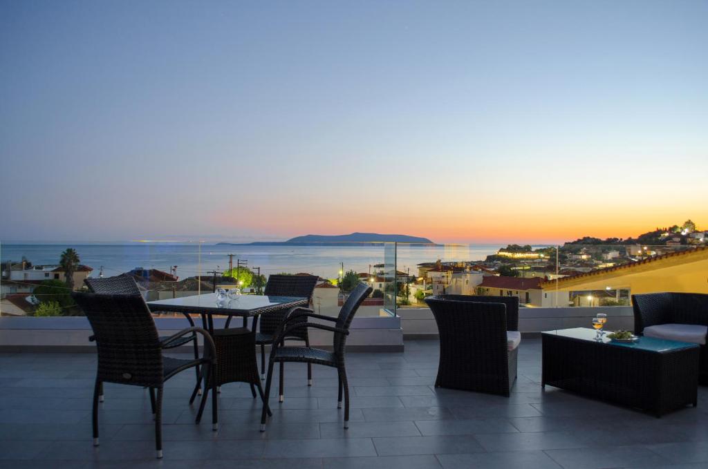 a patio with a table and chairs on a balcony at Hotel Estia in Finikounta