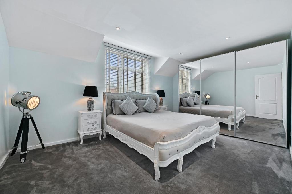 伦敦Hampstead Opulence Apartment - Luxurious Split Level Property的白色卧室配有床和镜子