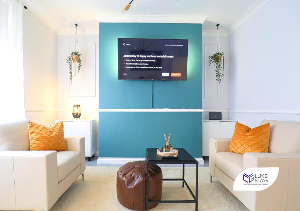 a living room with two couches and a tv on a wall at Luke Stays - Albert St, Chilton in Chilton