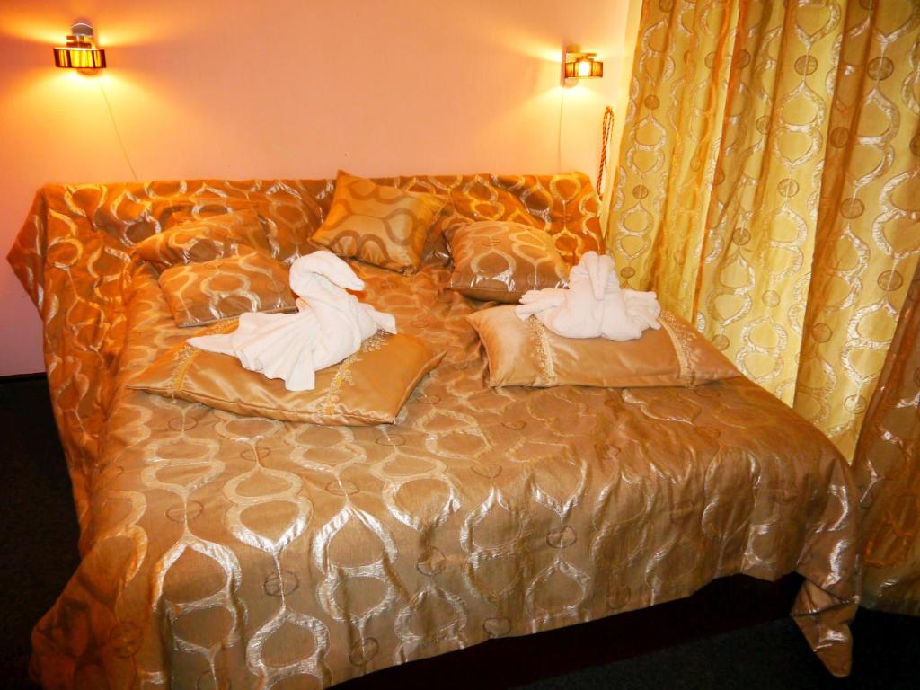 two swans are sitting on a bed with pillows at Kizhi ART Hotel Kharkiv in Kharkiv