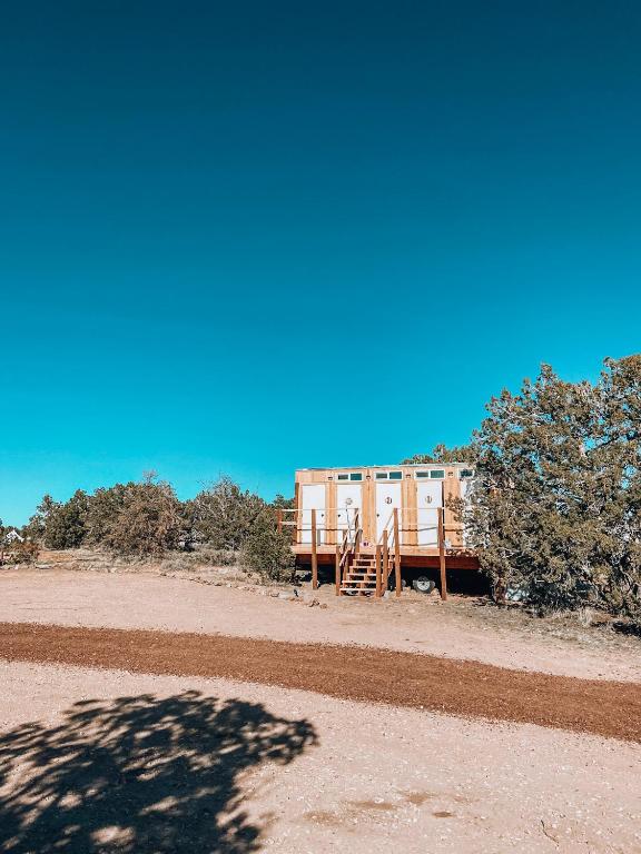 a house in the middle of a desert with a tree at Wander Camp Grand Canyon in Valle