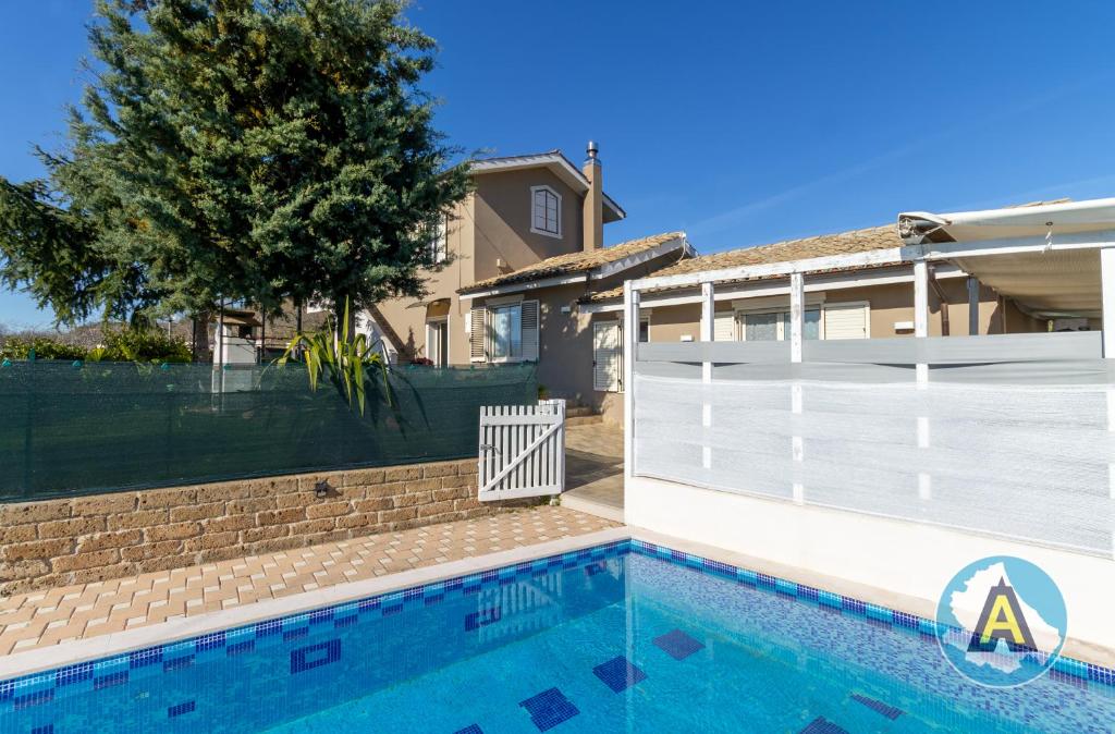 una piscina di fronte a una casa con recinzione bianca di Villino Fonte del Mare a Silvi Paese