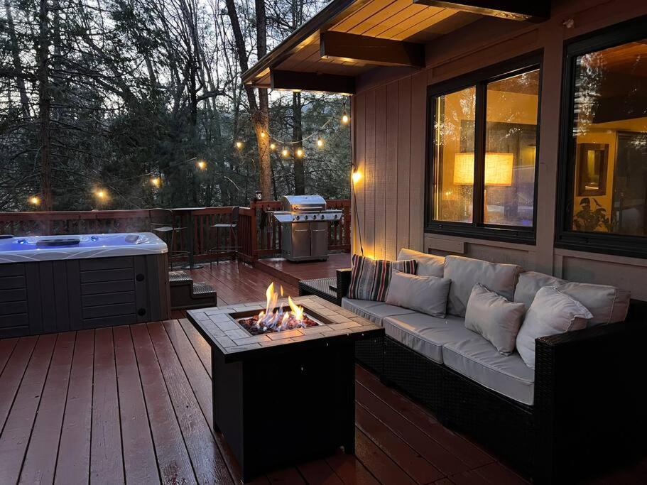 eine Terrasse mit einem Sofa und einer Feuerstelle in der Unterkunft Peaceful Oak Haven Cabin near Yosemite in Mariposa