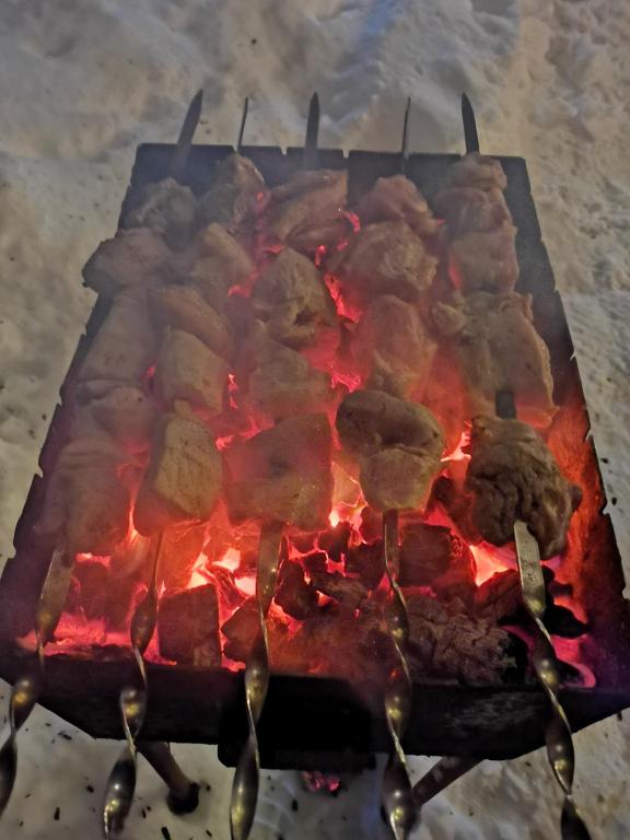 a grill with meat cooking on top of it at Guest House on Meskheti in Borjomi