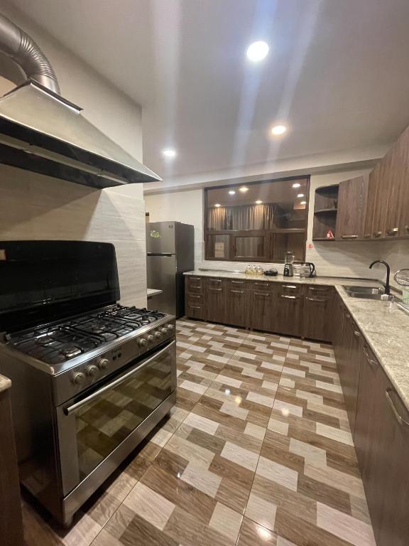 a large kitchen with a stove and a refrigerator at Guest House on Meskheti in Borjomi