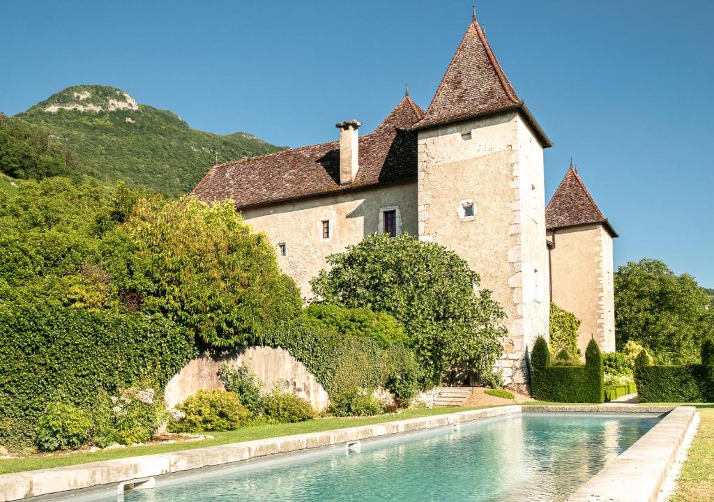 un castillo con piscina frente a un edificio en Château de La Mar Chambres d'Hôtes, en Jongieux