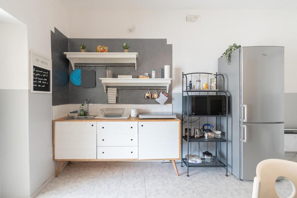 a kitchen with a white counter and a refrigerator at La CORTE di GIO' 1 in Nave