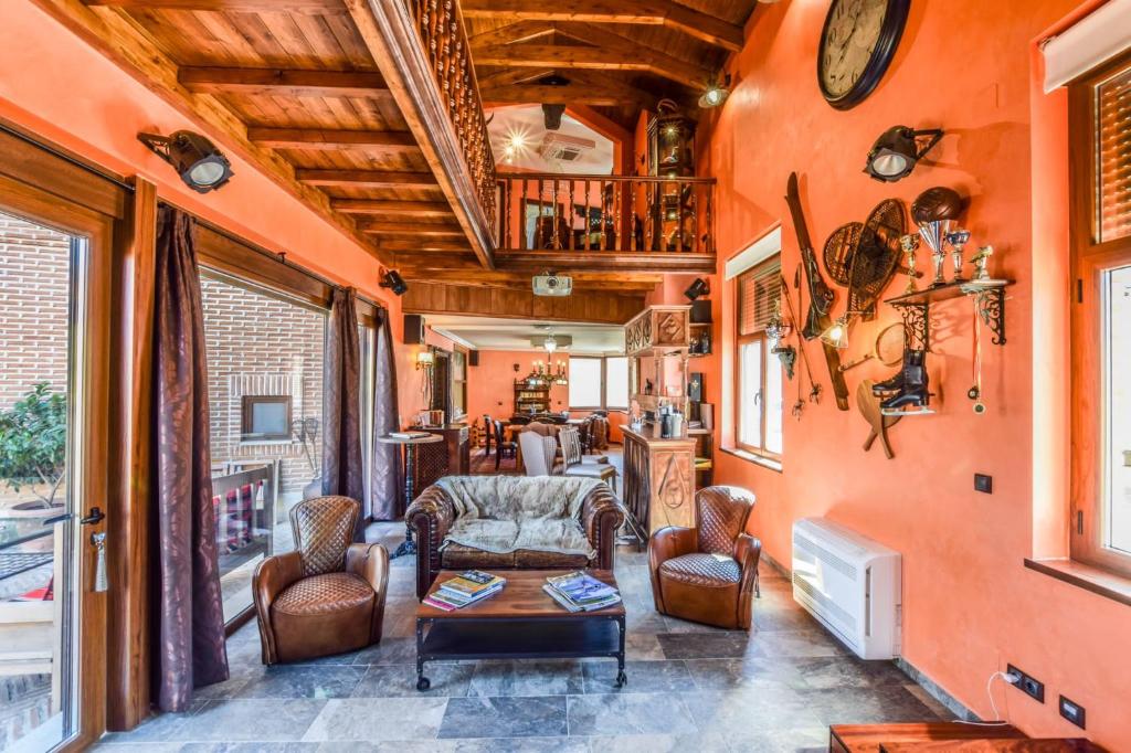 sala de estar con paredes de color naranja, mesa y sillas en Casa del Trotamundos, en Villamayor de Campos
