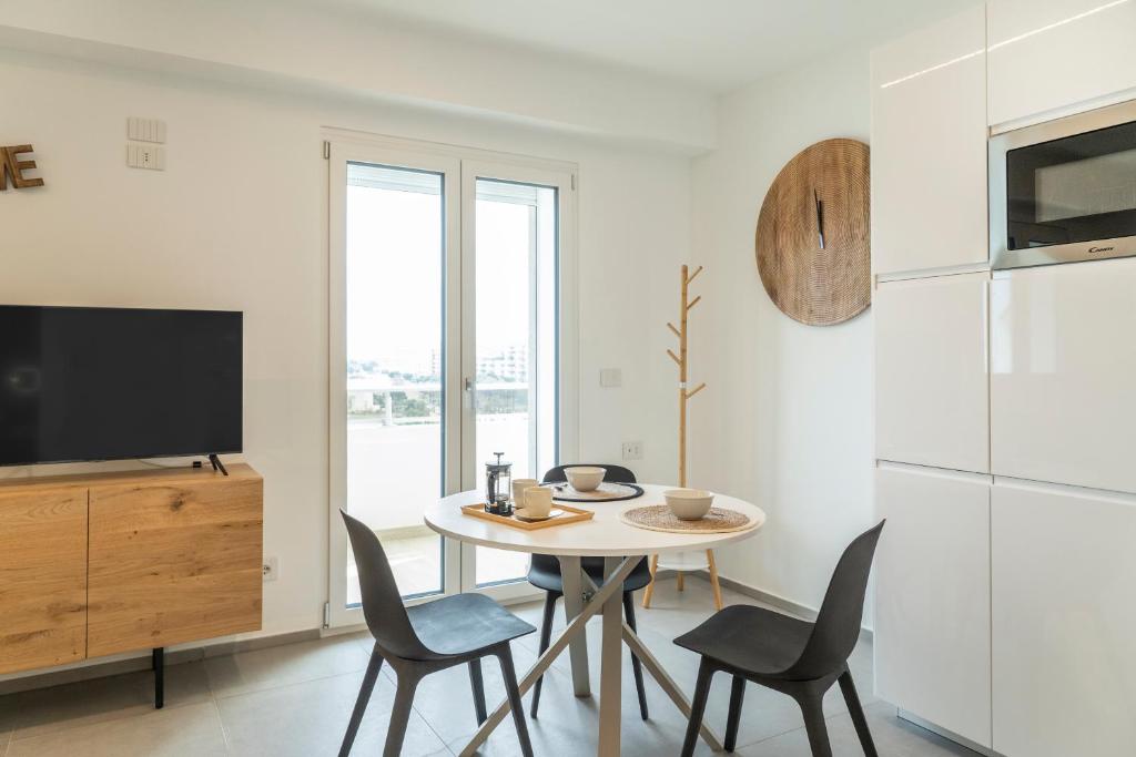 una sala da pranzo con tavolo, sedie e TV di Gentile 46 Blu Luxury Flat a Bari