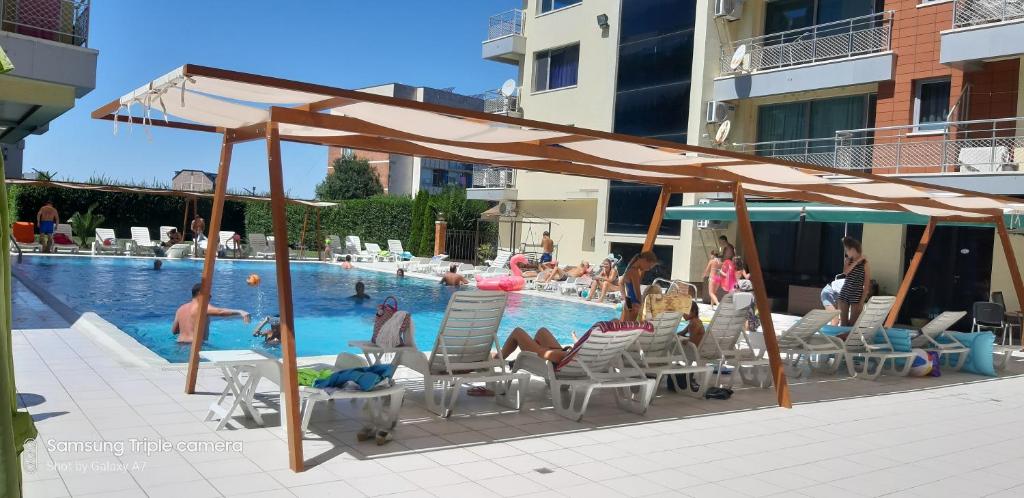 un gruppo di persone seduti su sedie a bordo piscina di Apartament Milenium a Pomorie