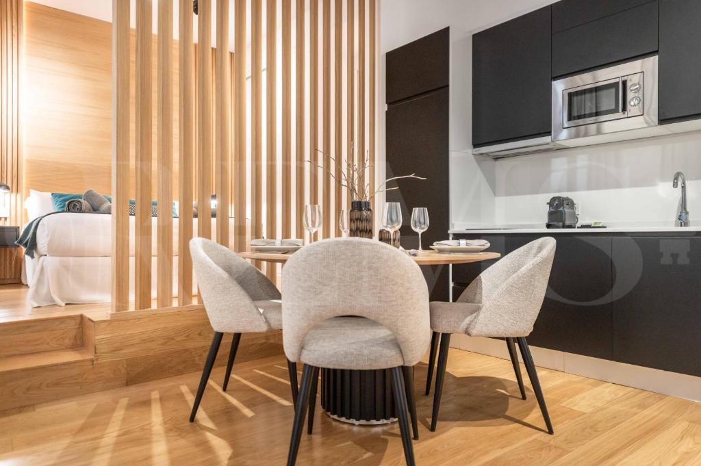 una sala da pranzo con tavolo e sedie e una cucina di Elegant studio in the heart of Malaga by REMS a Málaga