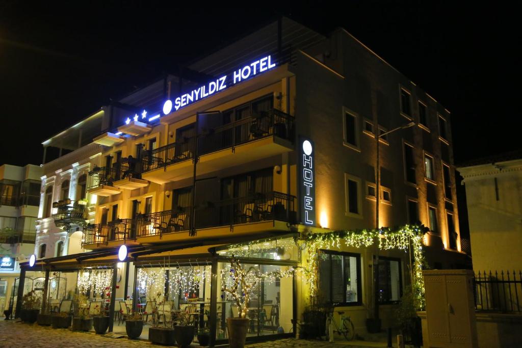 a building with a sign for a hotel at night at Şenyıldız Hotel in İzmir