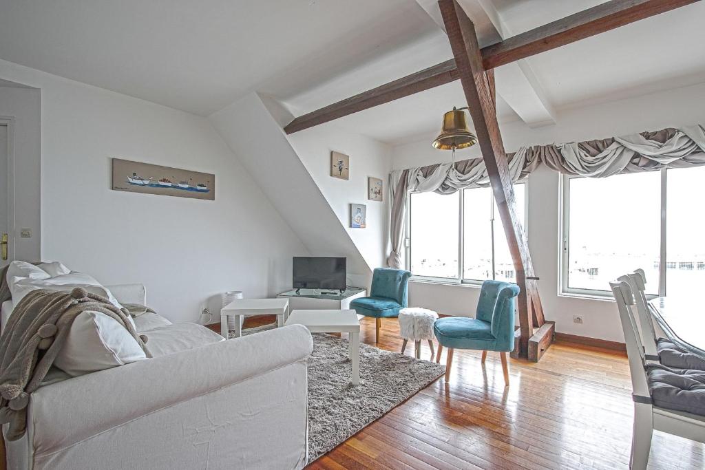 uma sala de estar com um sofá branco e duas cadeiras em Côté cottage beautiful view to the harbor ! em Étreham