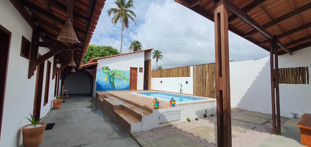 a swimming pool with a mural on the side of a building at Kbanas Milagres in São Miguel dos Milagres