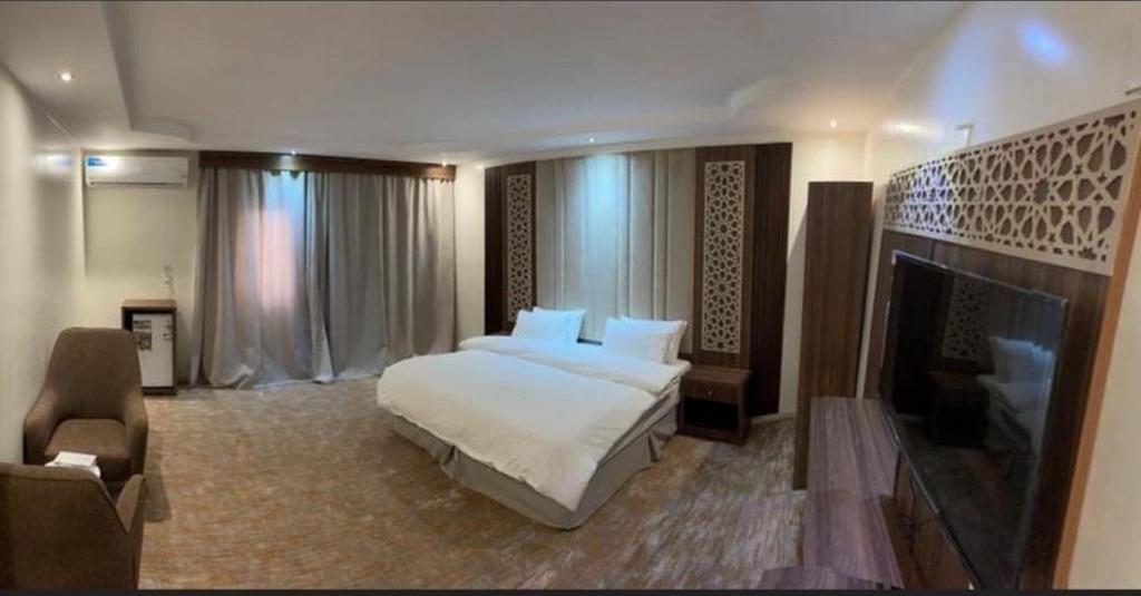 een grote slaapkamer met een bed en een open haard bij Najma ApartHotel in Jeddah