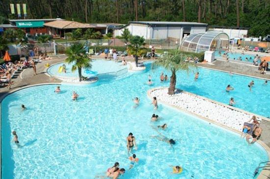 un groupe de personnes dans une grande piscine dans l'établissement Chris et Sabrina - Camping Les Viviers 4 étoiles, à Lège-Cap-Ferret