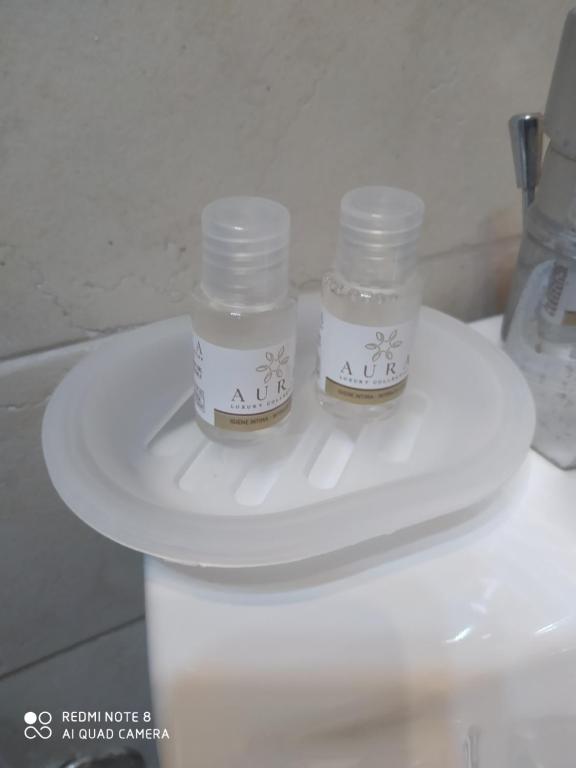 two glass jars sitting on top of a toilet at Casetta Santa Maria Degli Angeli in Santa Maria degli Angeli
