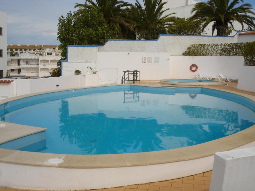 a large swimming pool with blue water at Erike Guest House in Carvoeiro