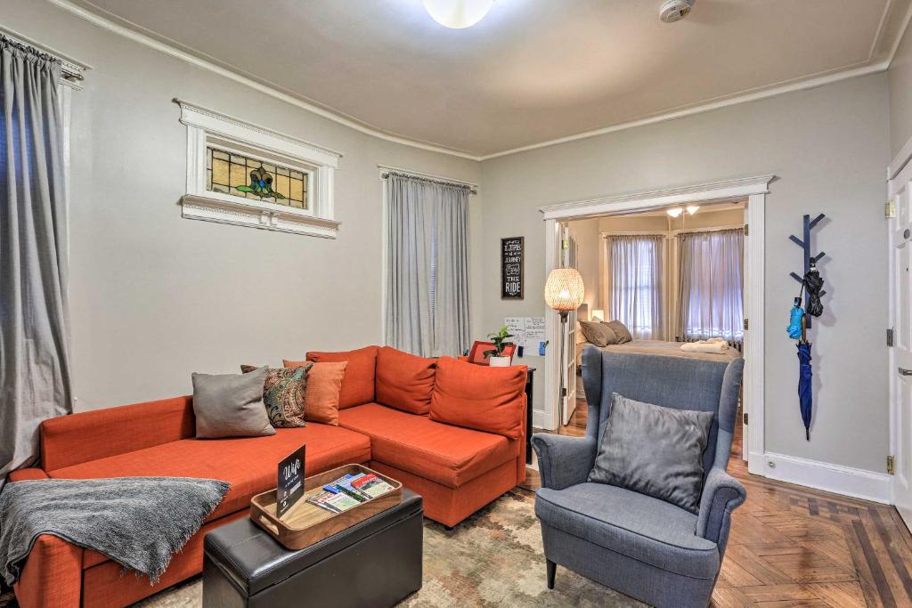 a living room with an orange couch and a chair at Jersey City Apartment Near Liberty State Park in Jersey City