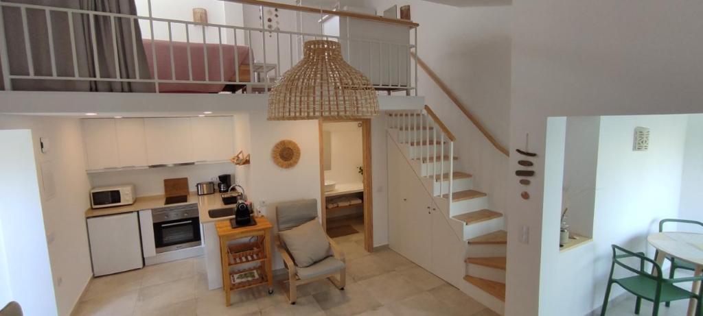 een woonkamer met een trap en een keuken met een tafel bij Cosy Beach Loft Pedras Del Rei in Pedras de El-Rei